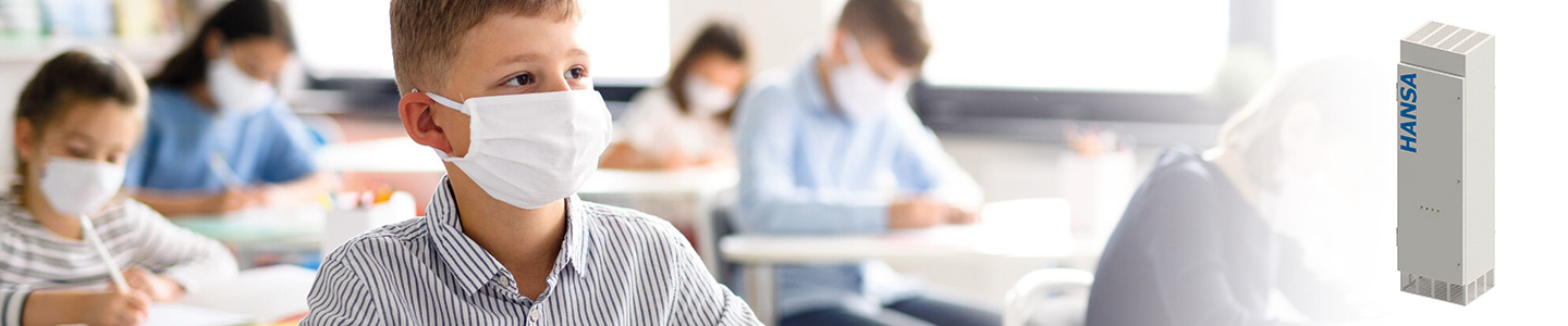 Kind mit Mund-Nasen-Schutz in Klassenraum